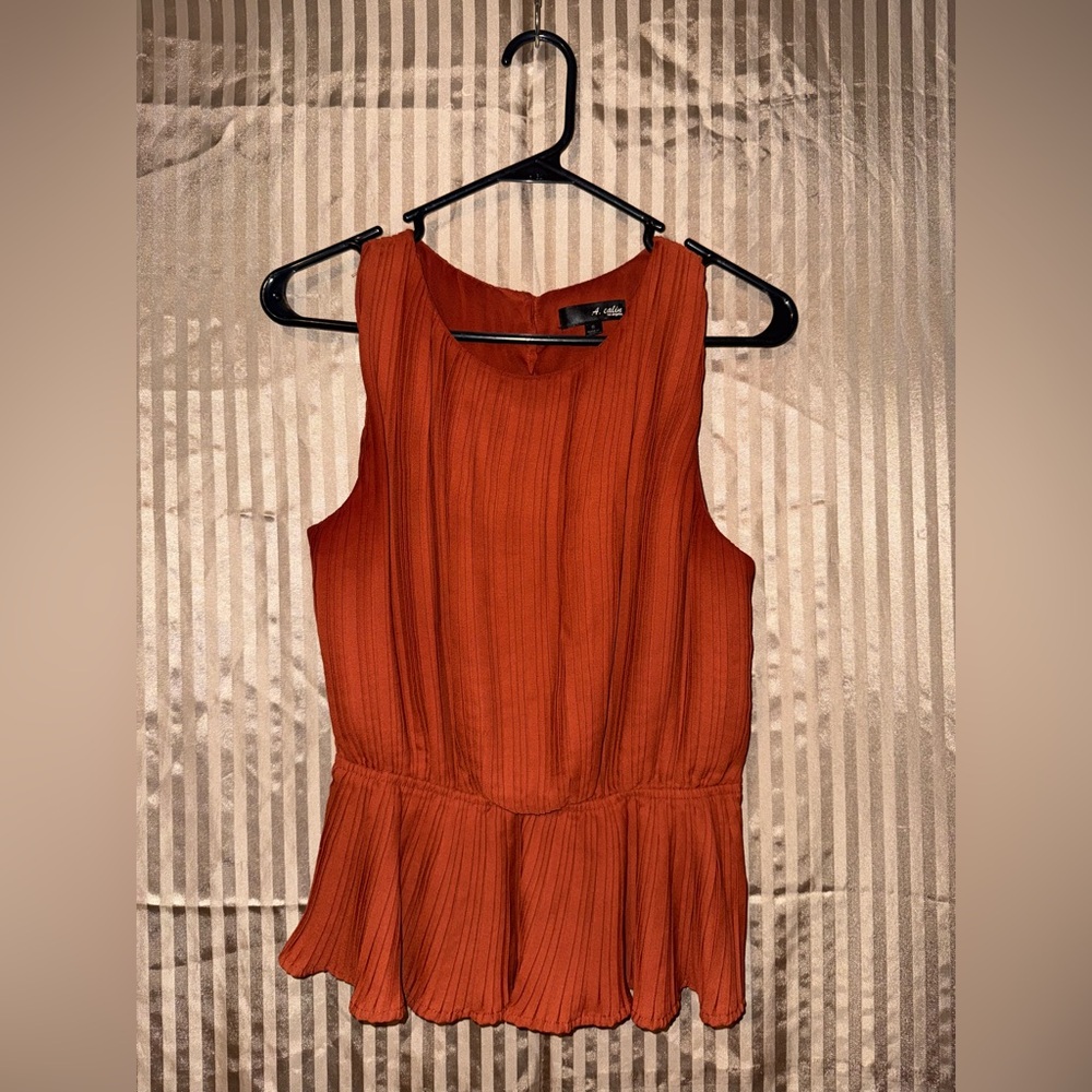 A. Calin Los Angeles burnt orange sleeveless peplum top